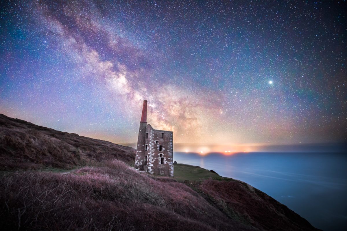 astrophotography of the milky way over a derelict wheal house on the coast of cornwall
