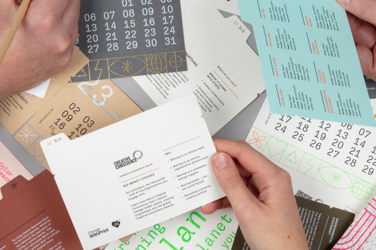 Change WithPrint 2023 calendar photo. Hands holding cards with other cards in the background